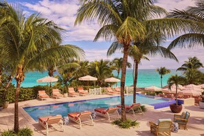 Een buitenzwembad, parasols bij het zwembad en ligstoelen