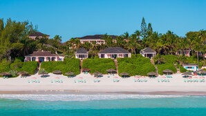 A beachfront property with multiple villas, a sandy beach, and a clear blue sea. - Coral Sands Inn & Cottages (Dunmore Town)