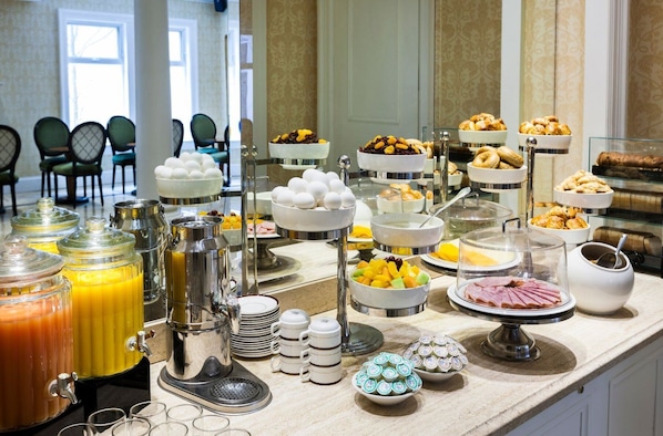 A buffet with various food items, including eggs, fruits, pastries, and beverages. - Chateau Versailles (Montreal)