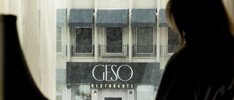 Un edificio con un cartel que dice 'GESO RISTORANTE' y vista de la calle.