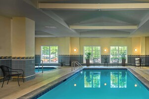 Una piscina techada, sillones reclinables de piscina