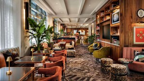 A hotel lobby with seating areas, a reception desk, and a large wooden bookshelf. - Sofitel Philadelphia at Rittenhouse Square (Philadelphia)