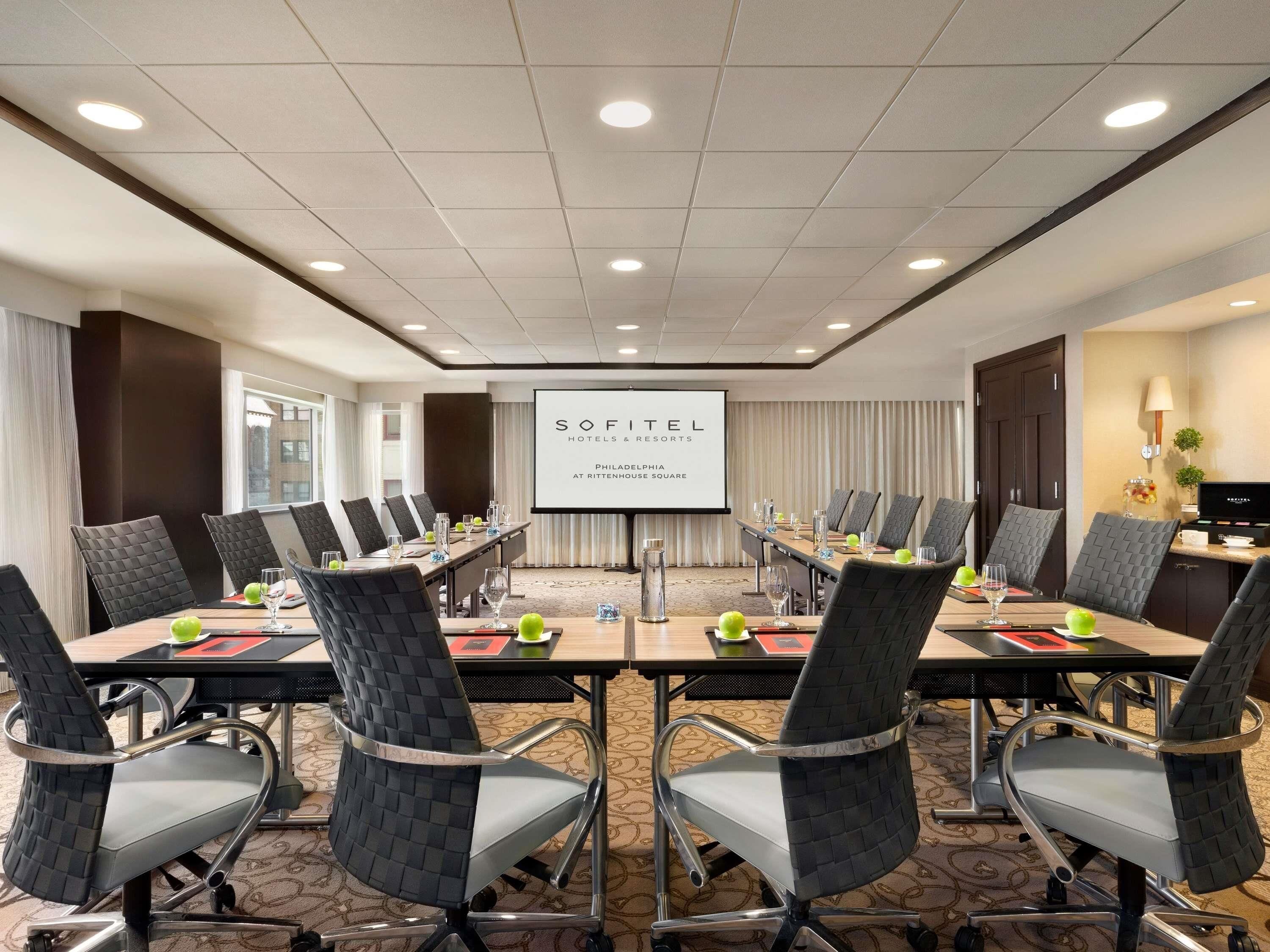 Une salle de conférence dotée d’un grand écran affichant la mention « SOFITEL HOTELS & RESORTS PHILADELPHIA AT RITTENHOUSE SQUARE », le tout dans un cadre hôtelier.