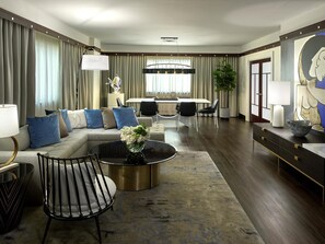 A modern living room with a sectional sofa, a coffee table, and a dining area with chairs.