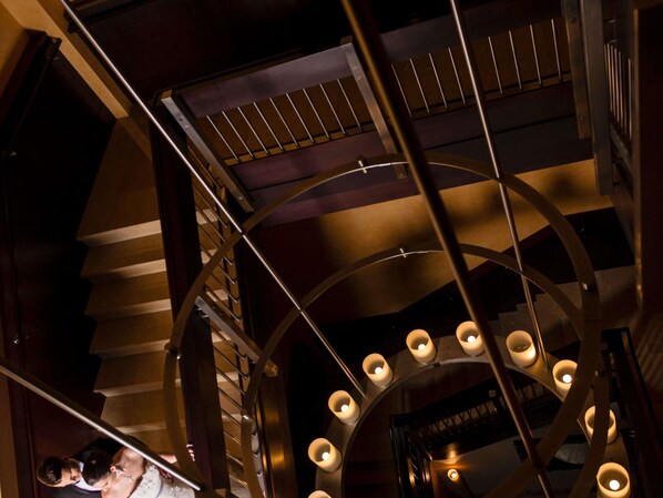A spiral staircase with a railing, a circular ceiling design, and multiple light fixtures. - Sofitel Philadelphia at Rittenhouse Square (Philadelphia)