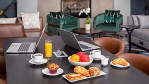 A dining table with breakfast items, two laptops, and a coffee cup. - Hilton Garden Inn Washington DC Downtown (Washington)