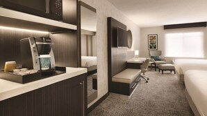 Une chambre d’hôtel équipée d’une kitchenette, d’un lit, d’un bureau, d’une chaise et d’un téléviseur.