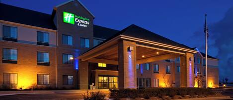 A Holiday Inn Express & Suites hotel with a covered entrance and a flagpole.