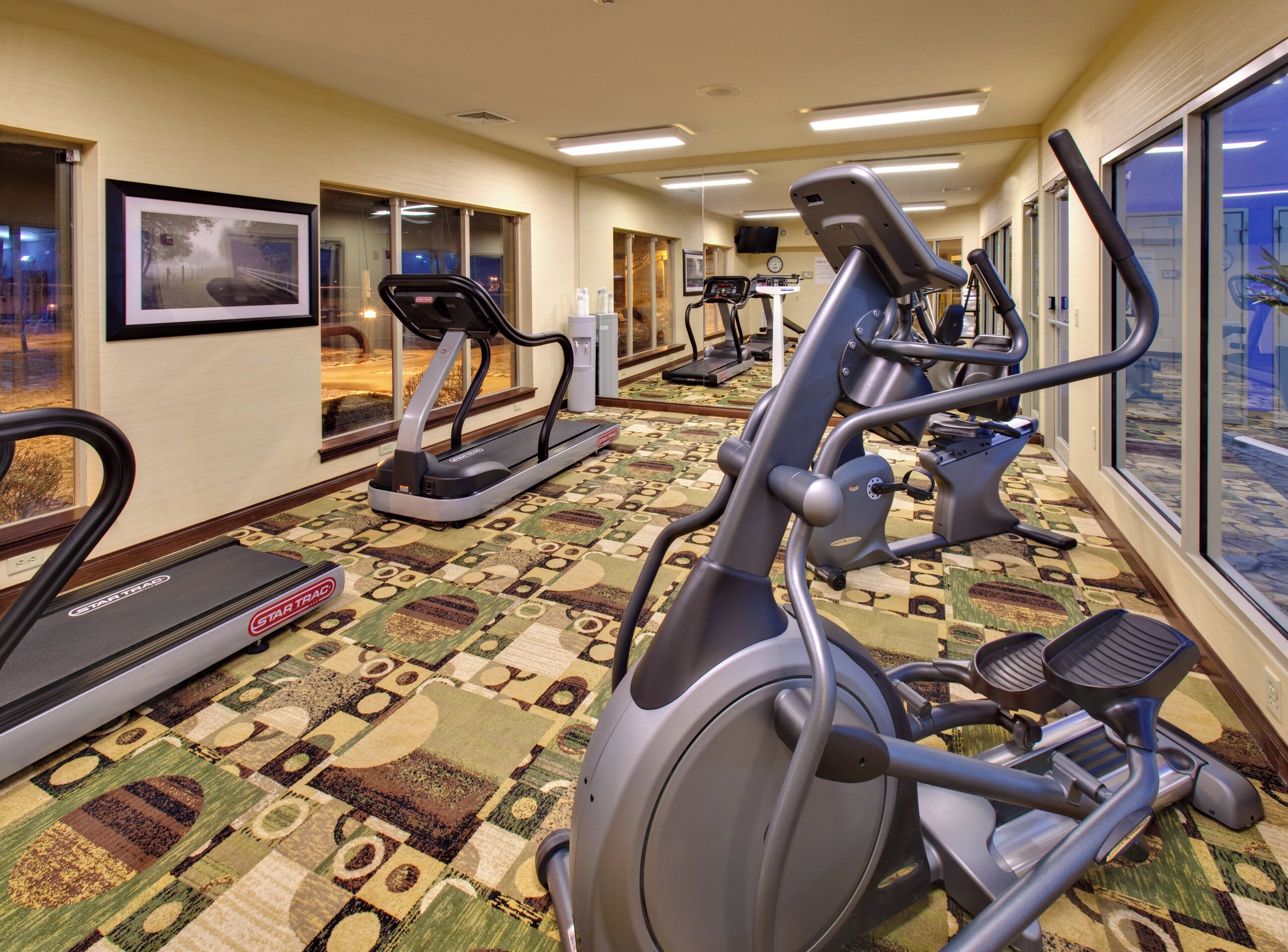 A hotel fitness center with treadmills, an elliptical, and a stationary bike.