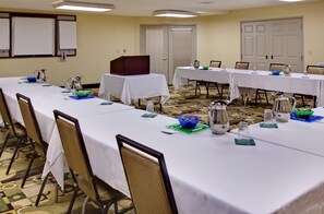Meetings take place in this well-equipped conference room with a long table and comfortable seating.