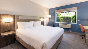 A hotel room with a large bed, bedside tables, a desk, and a window with a view of greenery. - Holiday Inn Express Hotel & Suites Pleasant Prairie-Kenosha by IHG (Pleasant Prairie)