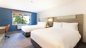 A hotel room with two beds, a desk, and a window with a view of trees. - Holiday Inn Express Hotel & Suites Pleasant Prairie-Kenosha by IHG (Pleasant Prairie)