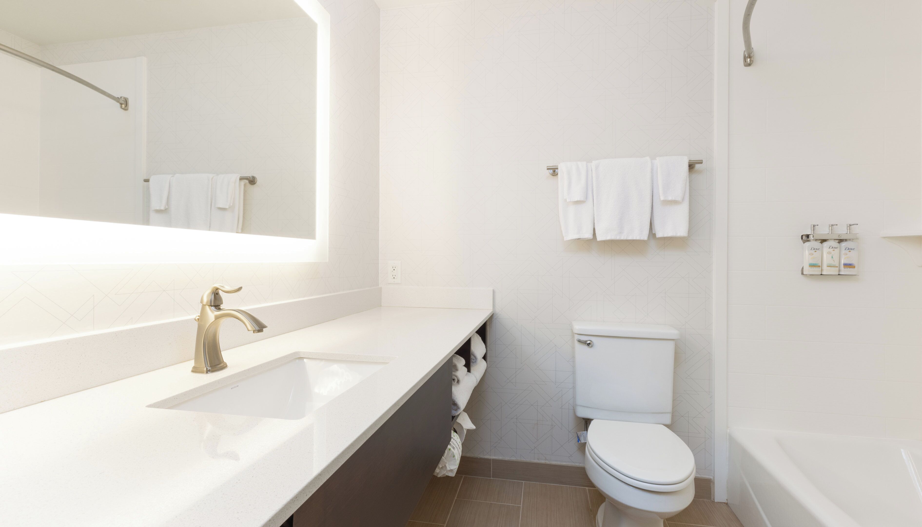A modern bathroom with a white sink, a toilet, and a bathtub.