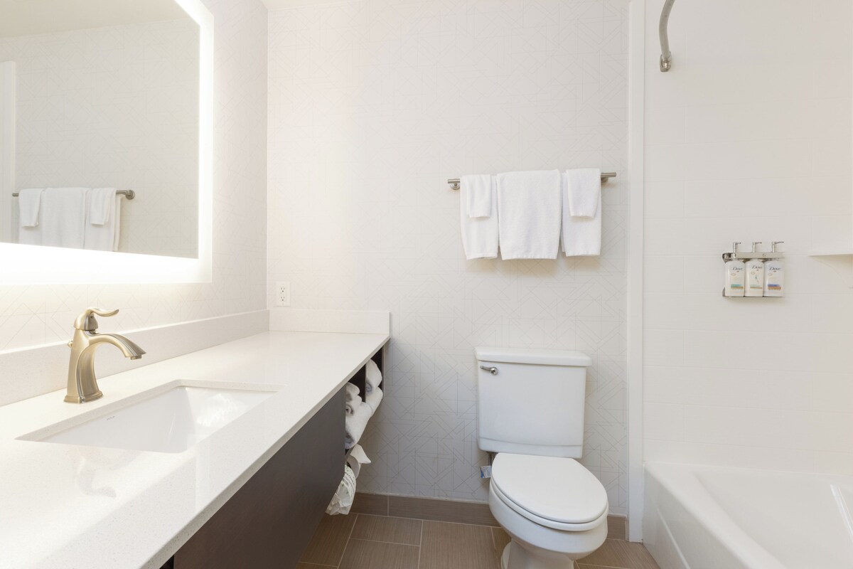 A modern bathroom with a white sink, a toilet, and a bathtub.