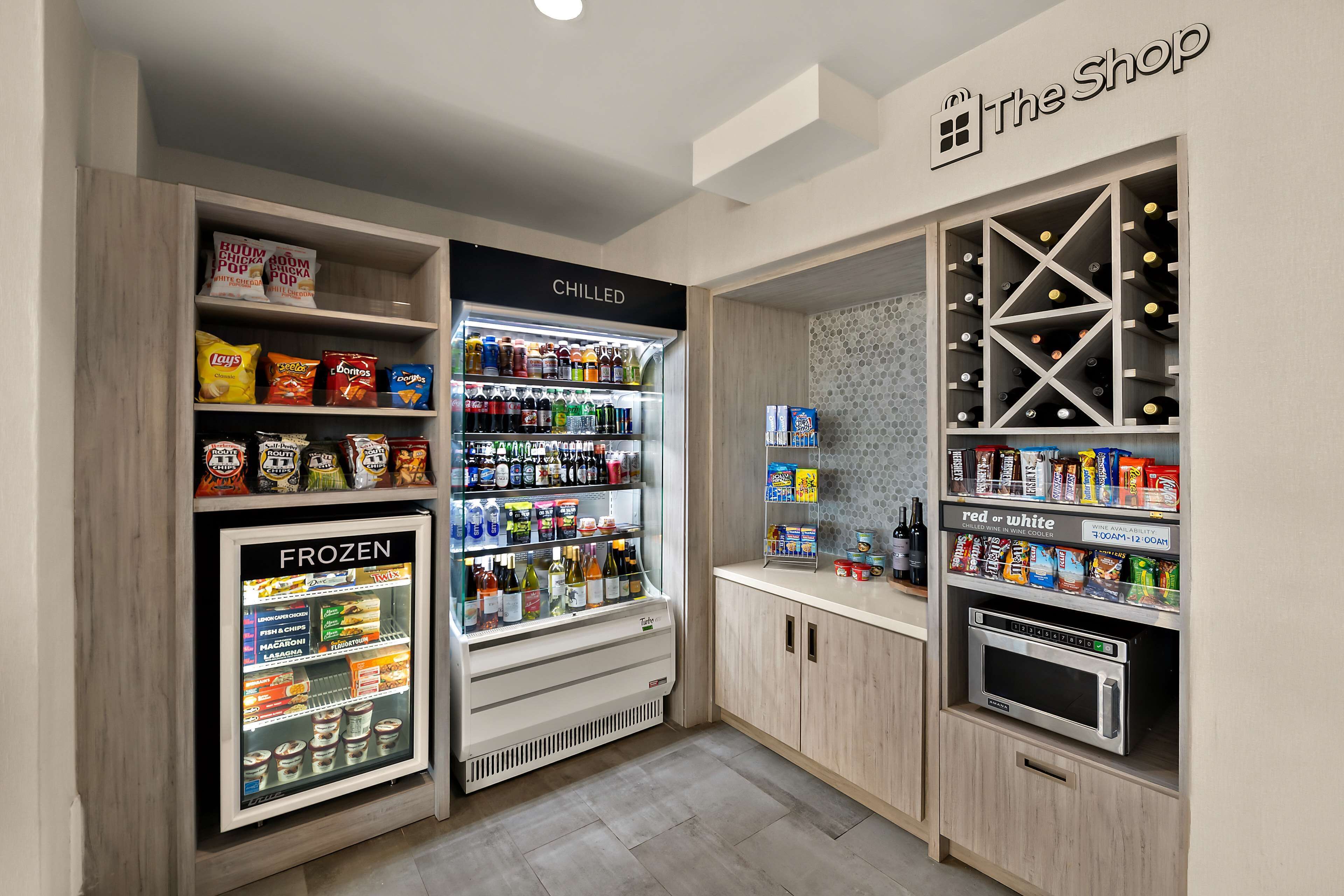 A kitchenette with a fridge, freezer, and wine storage.