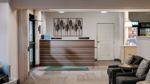A hotel reception area with a modern design, featuring a reception desk, seating area, and a minibar. - Homewood Suites by Hilton Boston / Andover (Andover)
