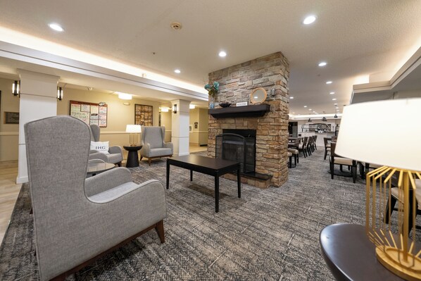 A modern lobby with a stone fireplace, comfortable seating, and a carpeted floor. - Staybridge Suites Columbia by IHG (Columbia)