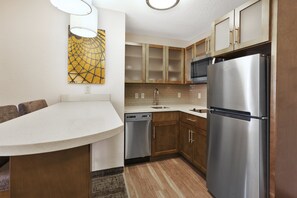 A modern kitchen with wooden cabinets, stainless steel appliances, and a white countertop. - Staybridge Suites Columbia by IHG (Columbia)