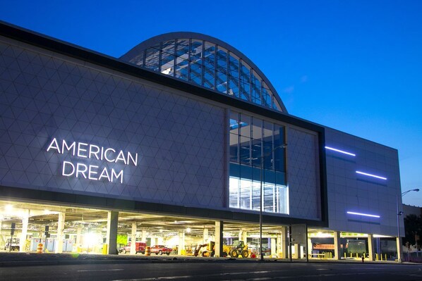 Un edificio moderno con un amplio muro de cristal y el texto "AMERICAN DREAM" en el lateral.