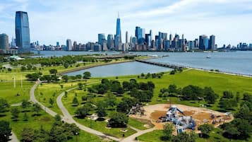 A park with a playground, a waterfront, and a city skyline in the background.