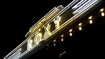 A neon sign with the letters "ROXY" in a stylized font, mounted on a metal structure.