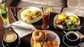 A table with breakfast items including eggs, avocado toast, smoked salmon, and coffee.