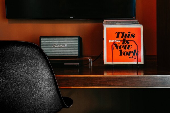 A desk with a laptop, a speaker, and a magazine titled "This granddaddy is New York vol. 3".