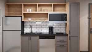 Una cocina moderna con gabinetes grises, un microondas negro y una cafetera.