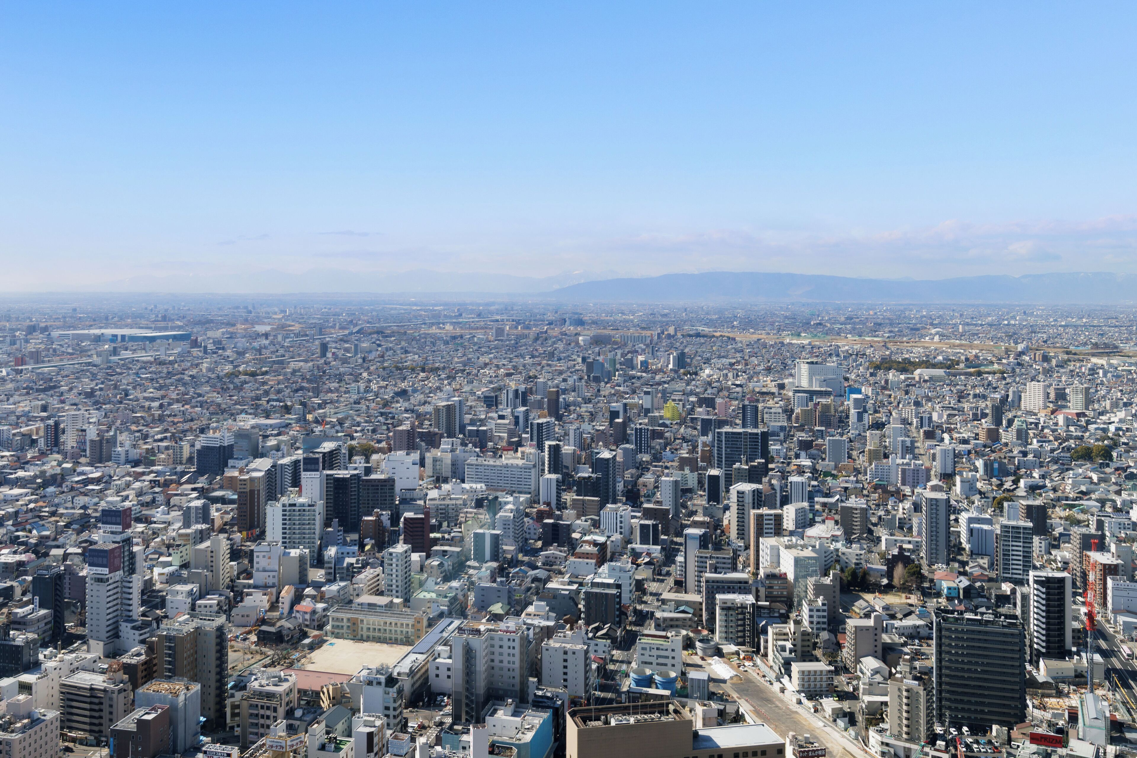 A densely packed urban cityscape with numerous high-rise buildings and a clear sky.