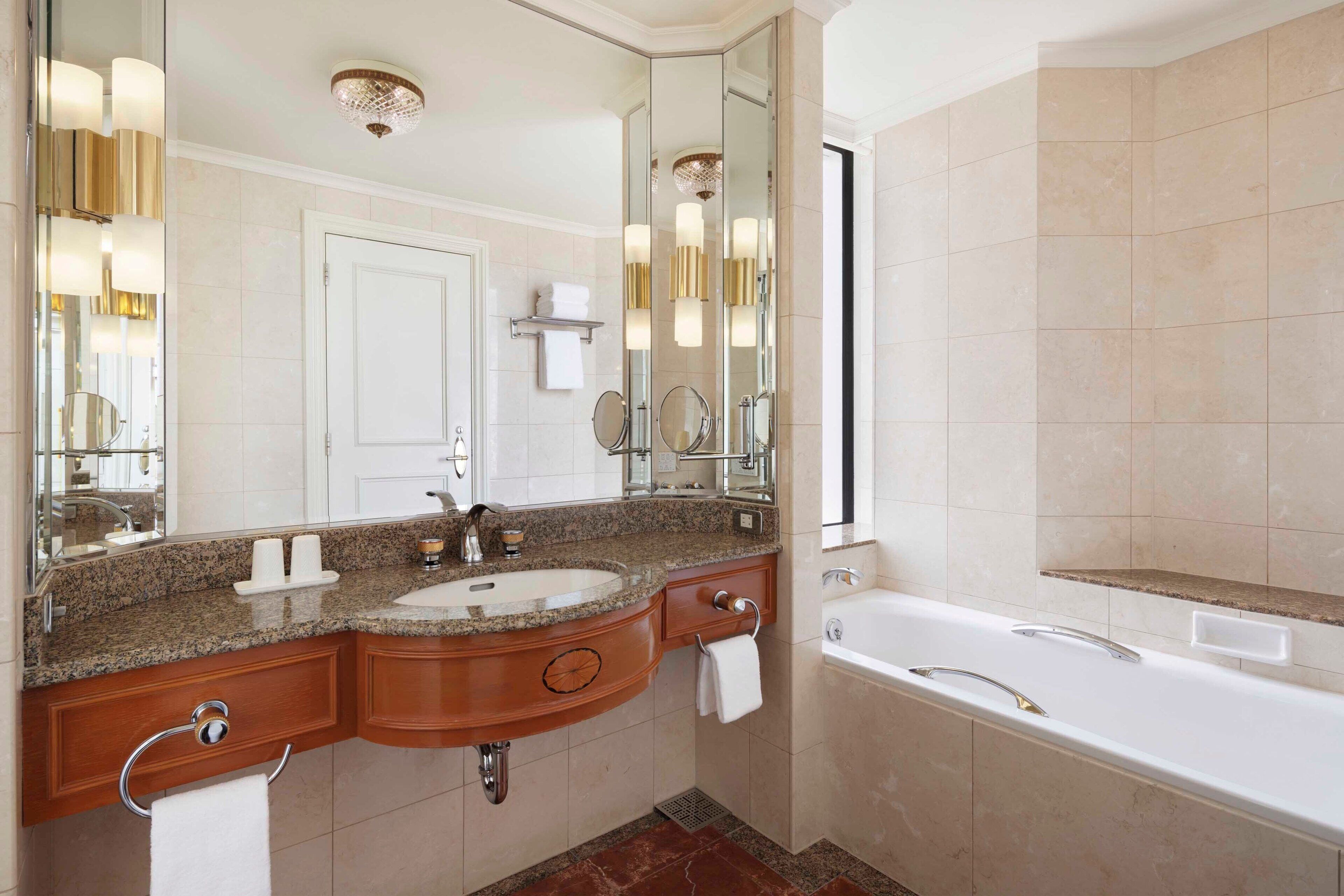 Un baño moderno con tocador doble, un espejo grande, una bañera y una zona de ducha.