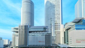 Un paisaje urbano moderno con dos imponentes rascacielos cilíndricos y varios edificios altos.