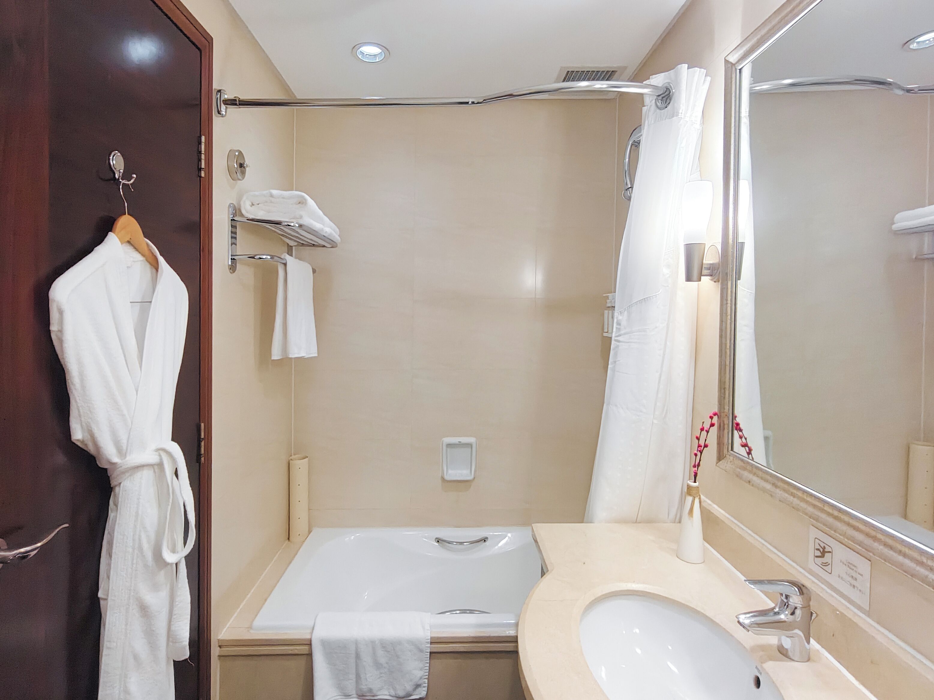 A bathroom with a bathtub, a sink, and a mirror.