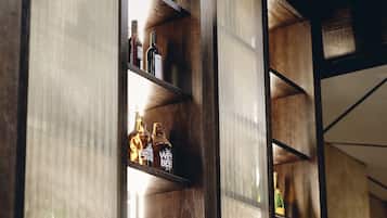 Una zona de bar con estantes de madera que exhiben diferentes botellas y vasos.