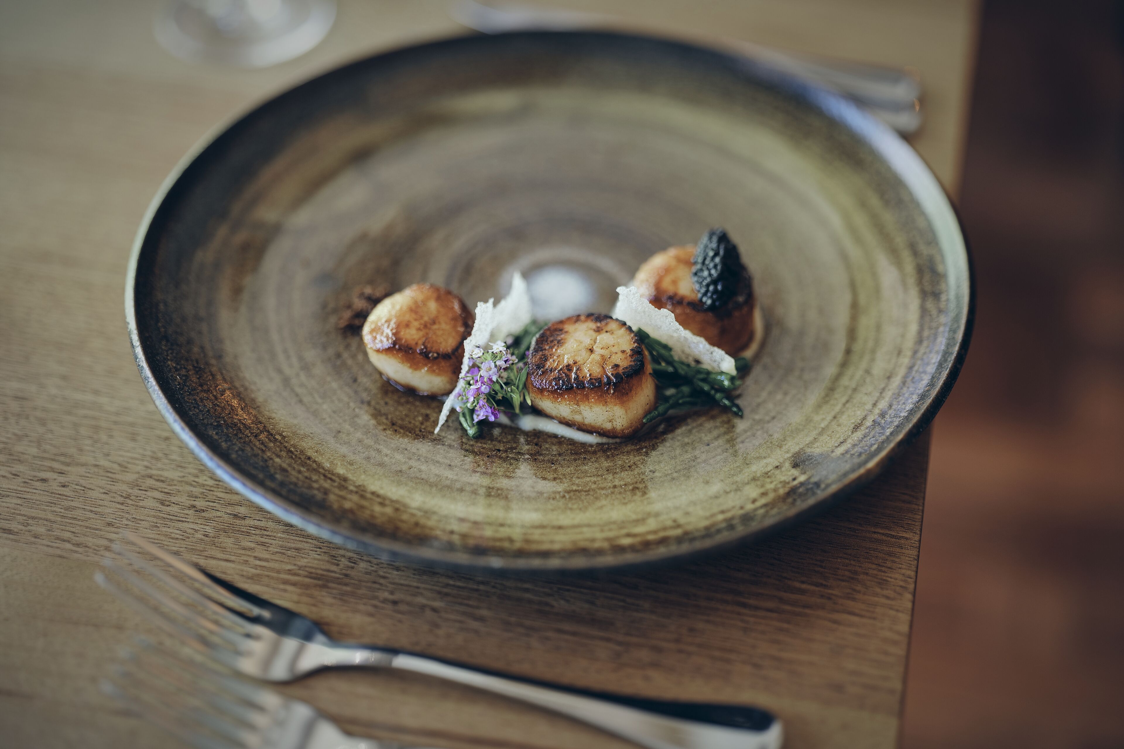 A plate with food on a wooden table.