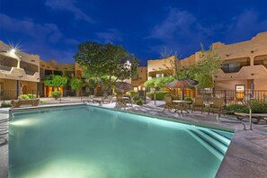 Una piscina al aire libre, tumbonas