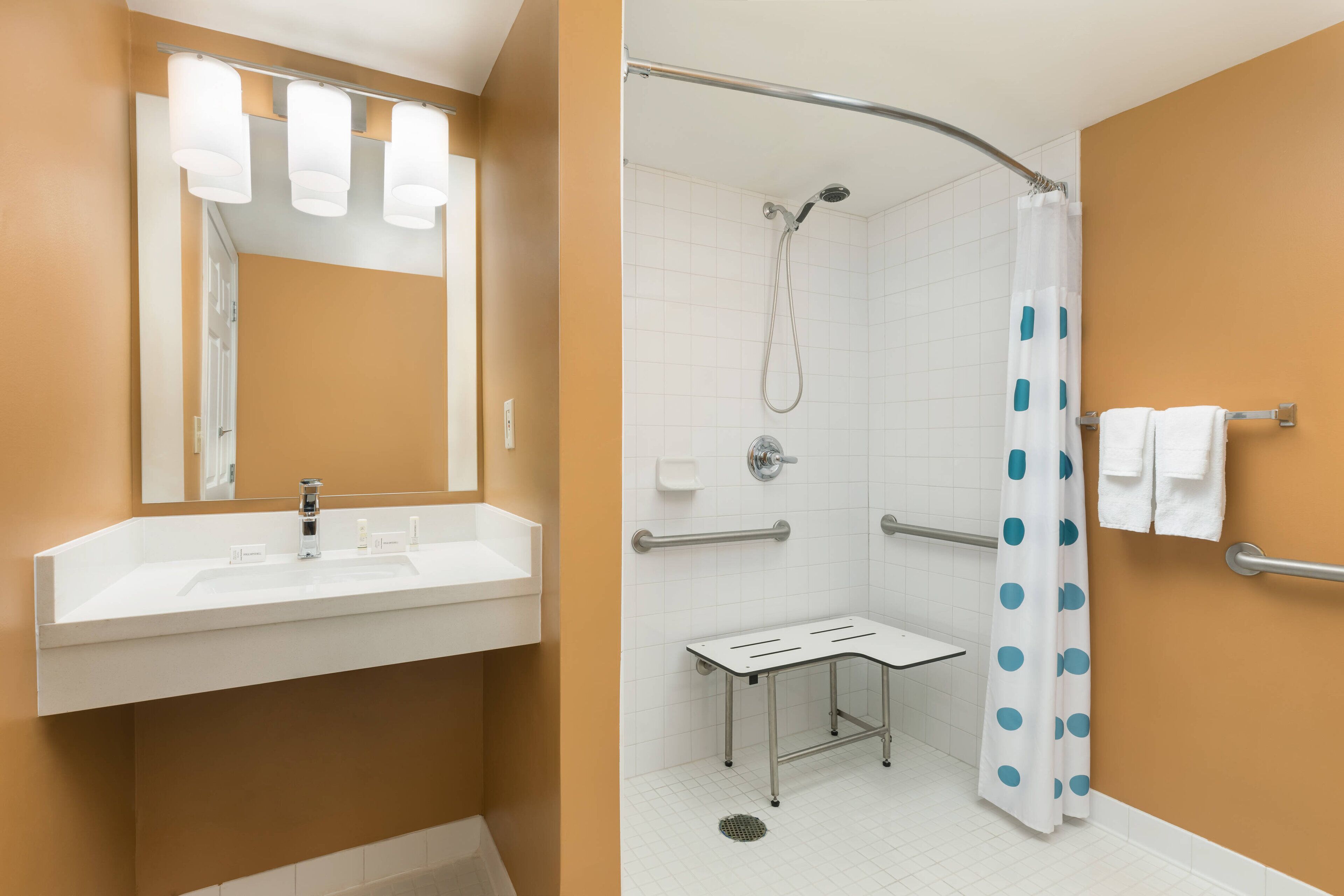 A bathroom with a white sink, mirror, and shower.