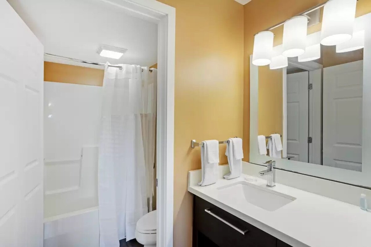 A bathroom with a white sink, a mirror, and a shower curtain.