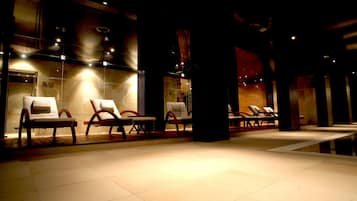 Relax in comfort with lounge chairs arranged along a tiled floor, surrounded by modern walls.