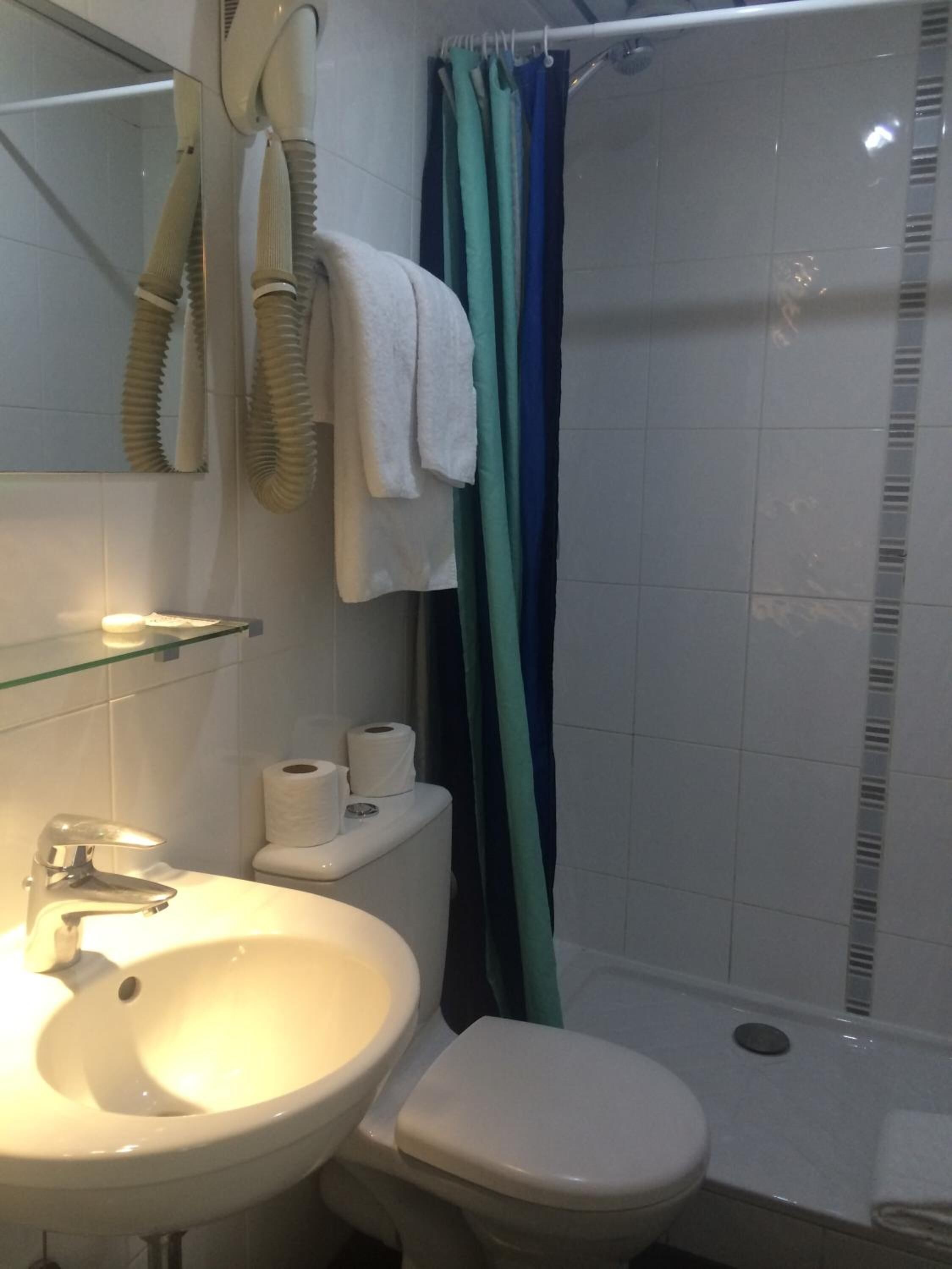 Un baño con lavabo, inodoro y ducha.