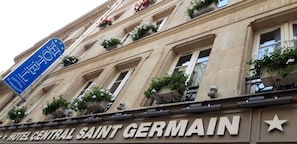 The facade of Hotel Central Saint Germain with a sign indicating its name and a blue sign with stars. - Hotel Central Saint Germain (Paris)