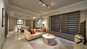 A modern living room with a sofa, coffee table, and dining area. - Great World Residences (Singapore)