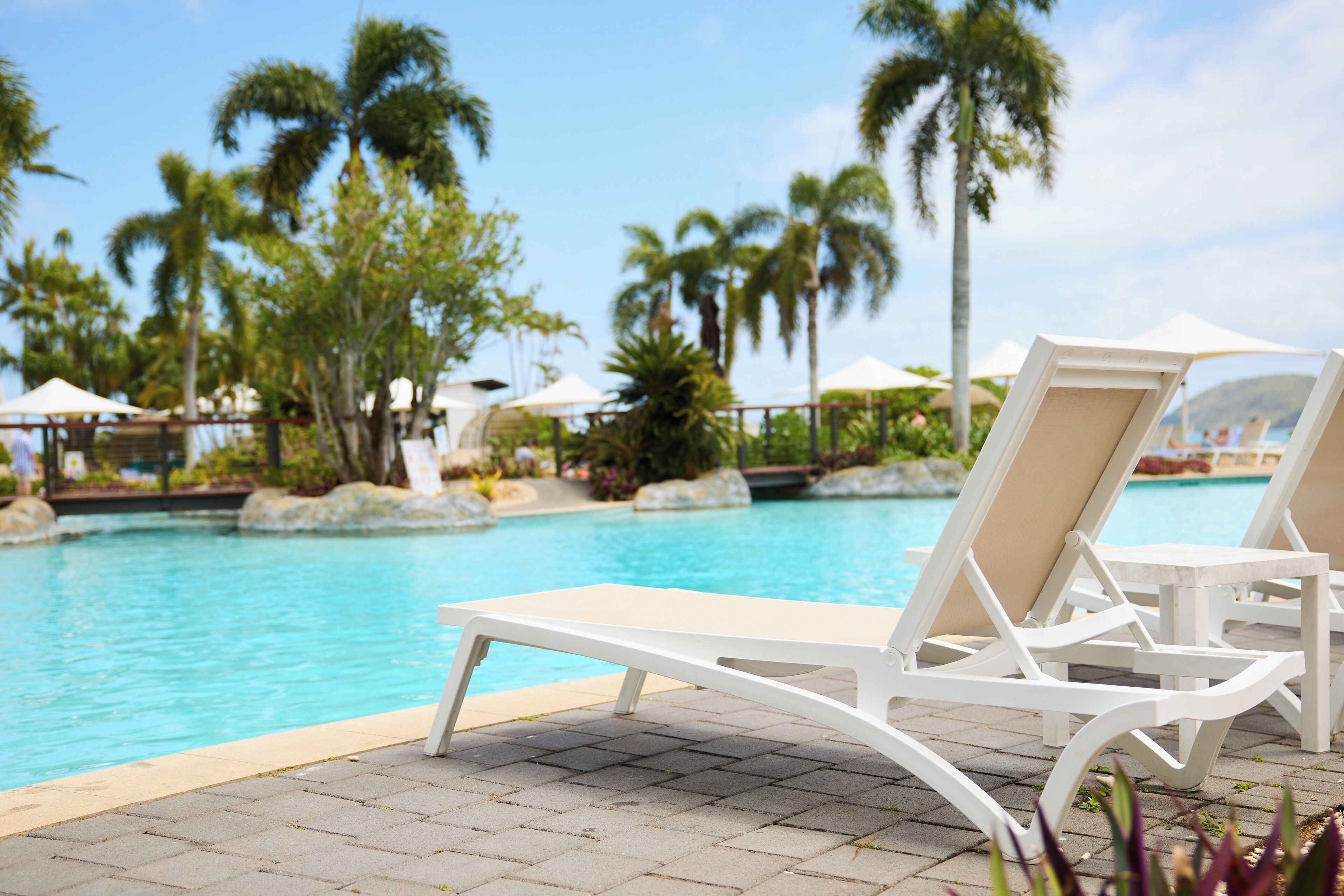 A poolside area with lounge chairs and umbrellas.