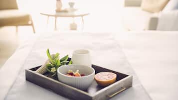 Bandeja con un cuenco de fruta, una taza y medio pomelo sobre una base.