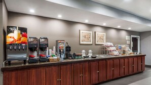 A self-service beverage station with multiple coffee machines, a water dispenser, and a variety of coffee pods. - Hawthorn Extended Stay by Wyndham Columbus West (Columbus)