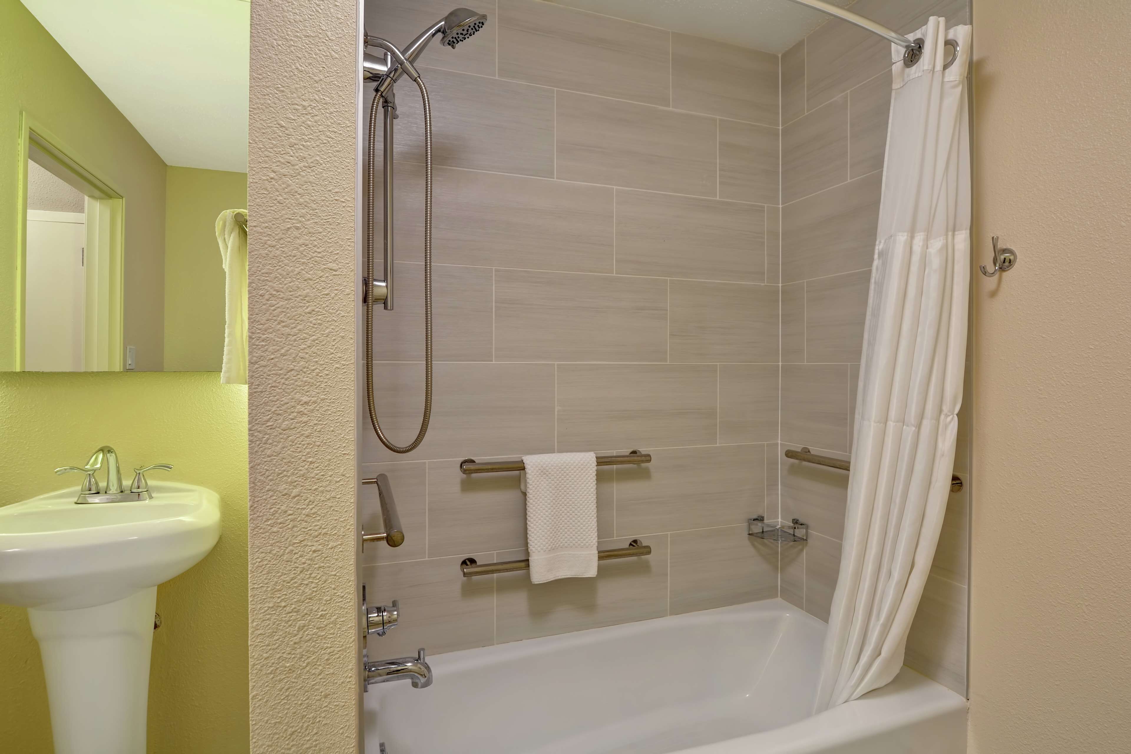 A bathroom with a bathtub, shower, and sink.