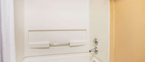 Une baignoire blanche avec un porte-serviettes et une pomme de douche.