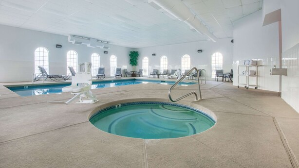 An indoor swimming pool with multiple lanes, lounge chairs, and a green plant. - Hawthorn Suites by Wyndham Las Vegas/Henderson (Henderson)