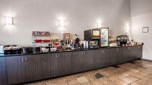 A buffet counter with various food items and a coffee machine. - Hawthorn Suites by Wyndham Las Vegas/Henderson (Henderson)