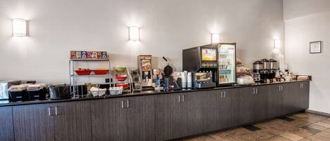 A buffet counter with various food items and a coffee machine.
