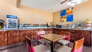A breakfast bar with seating, a coffee machine, and a waffle maker. - Comfort Inn & Suites McComb (McComb)